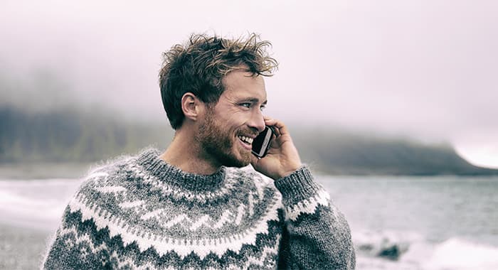 smiling man holding phone to his ear