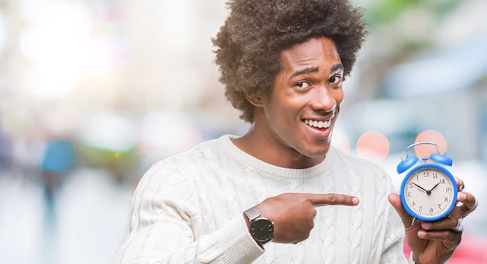 man pointing to holding a clock